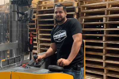 man stands by forklift