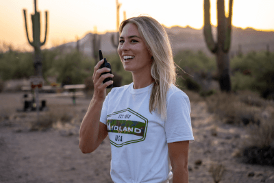 woman holding walkie talkie in desert