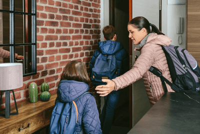 woman ushers kids out front door