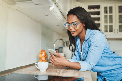 woman checks her phone in a kitchen