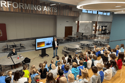 meteorologist speakers to kids at assembly