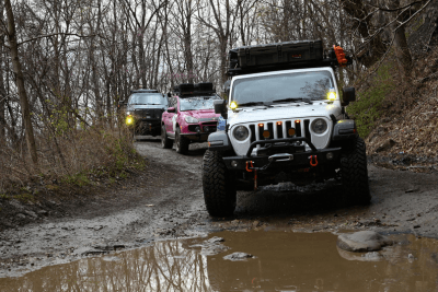 Jeeps on trail crossing water in forest on trail
