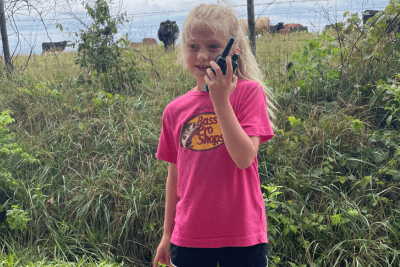 young girl uses walkie talkie on farm