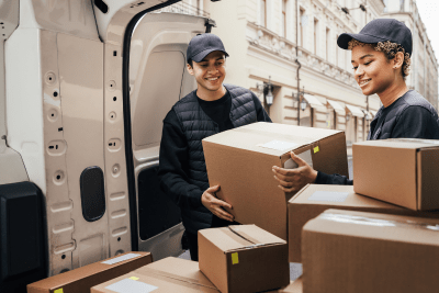 two delivery men unloading boxes from vehicle