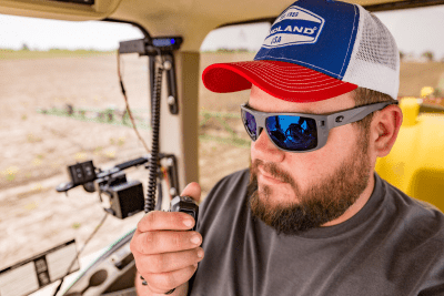 male farmer in tractor with mobile GMRS radio mic in his hand