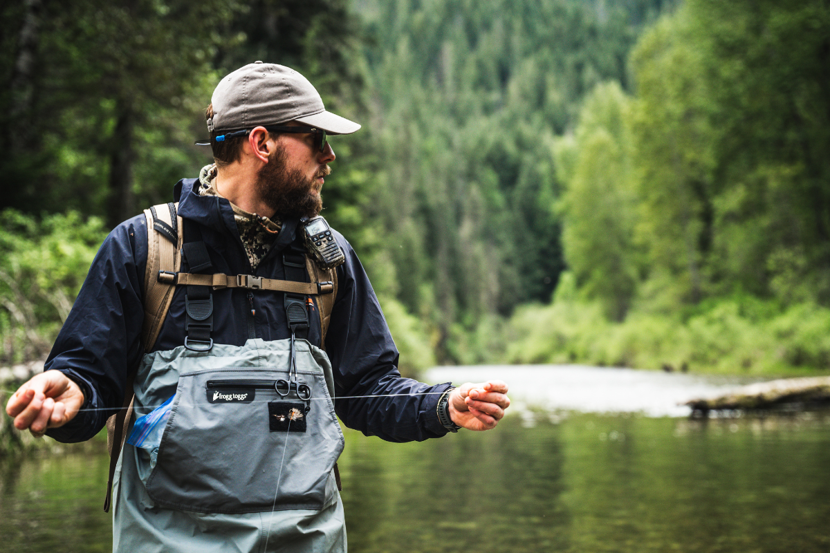 fly fisher stands in river