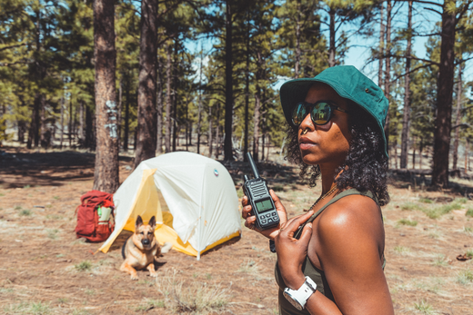 woman holds walkie talkie by tent