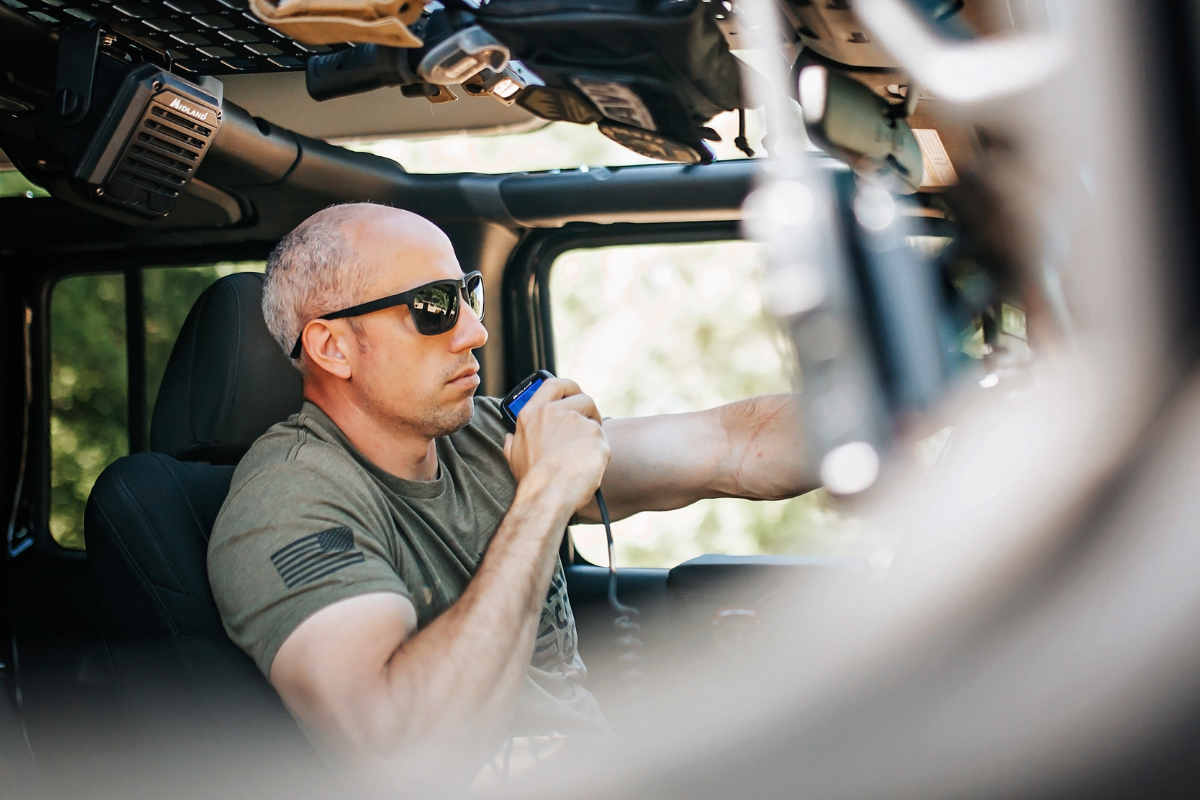 man in vehicle cab using external speaker