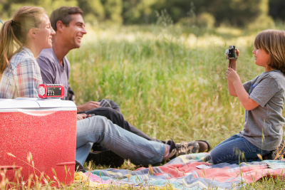 family sits outside with emergency radio