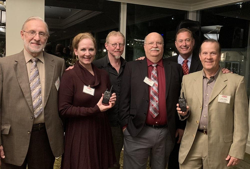 men stand in circle with award