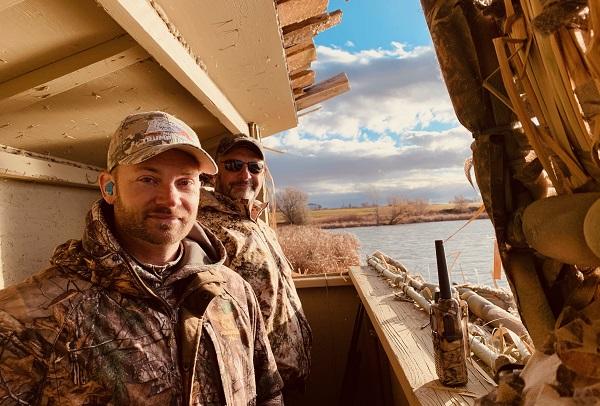 men in camo in shed with walkie talkie