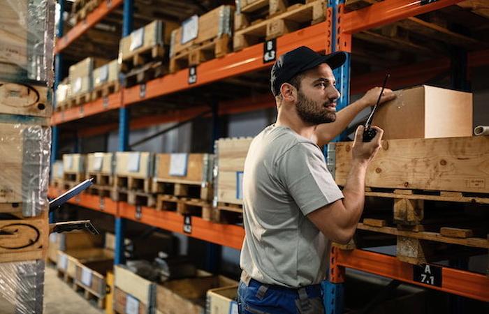 man uses business radio in warehouse