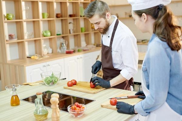 2 chefs cut tomatoes