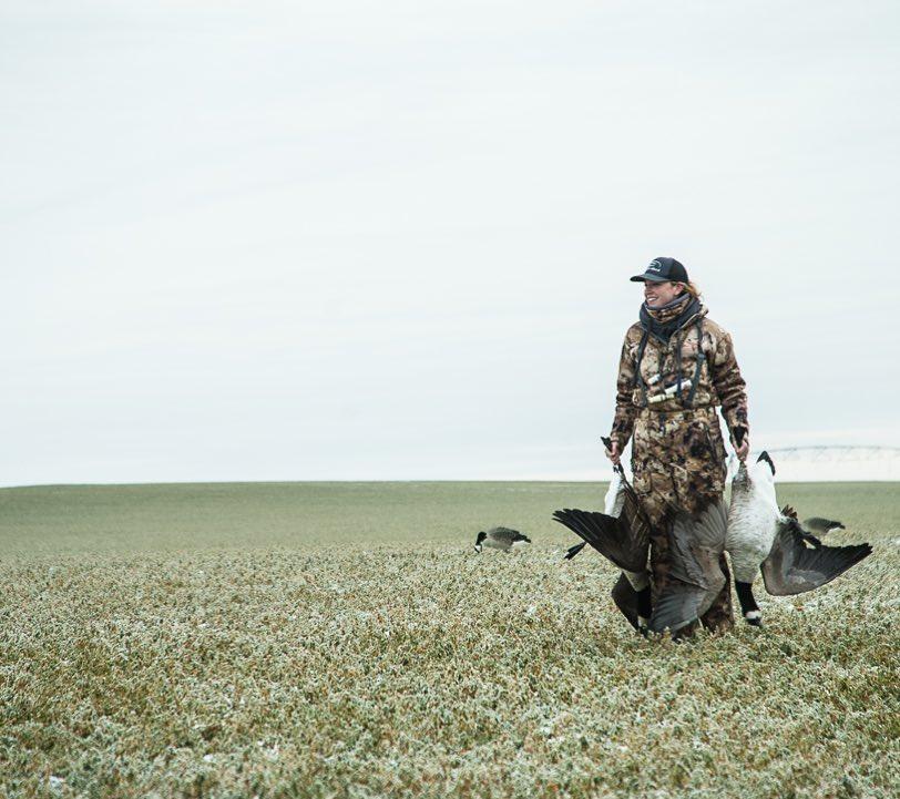 huntress walks with animals in grass