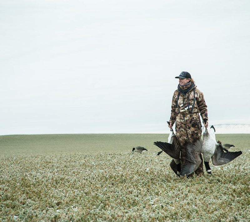 huntress walks with animals in grass