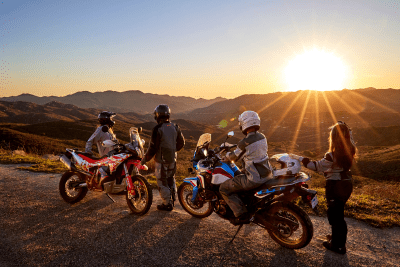 motorcycle riders pulled off to side of road with sunset