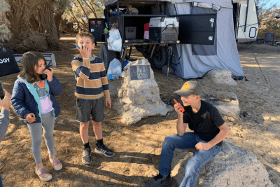 kids using multi-color walkie talkies at campsite
