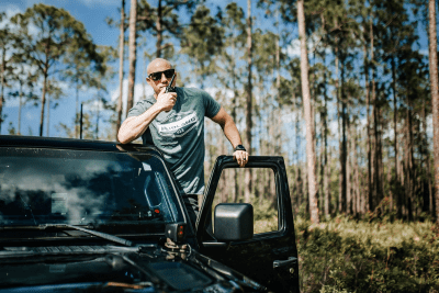 Off-Roader standing out door of vehicle with radio