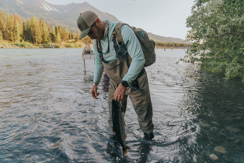fly fisher stands in water