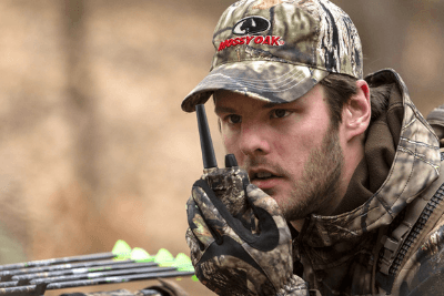 man holds camo walkie talkie