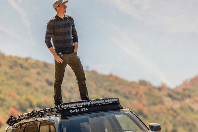 man stands on top of vehicle 