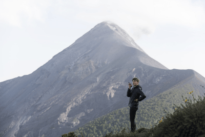 woman uses walkie talkie next to mountain