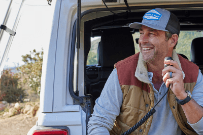 man uses MicroMobile mic in back of Jeep