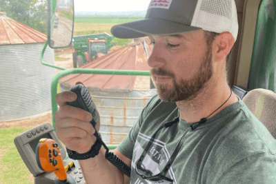 man uses radio mic in tractor cab