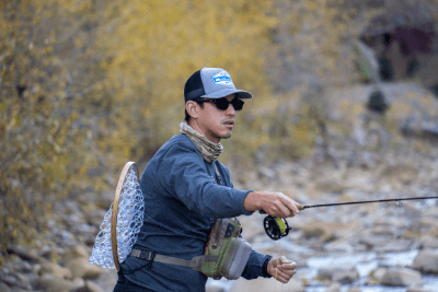 man casts fishing rod