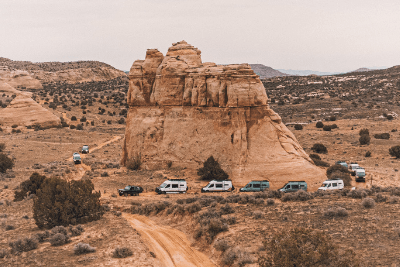 overlanding vehicles near large rock formation
