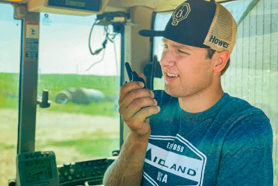 man in tractor cab with walkie talkie