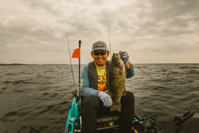 man holds fish on boat