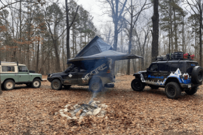 overlanding vehicles around camp fire