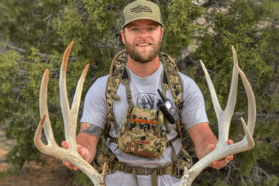 hunter holding antlers with walkie talkie