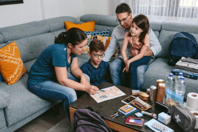 family sits around coffee table with supplies