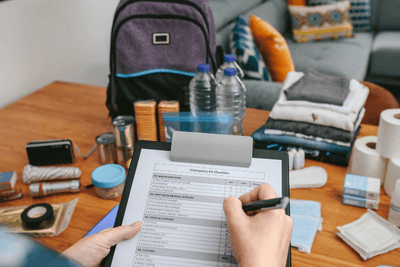 hand checks off list of gear going in emergency go bag