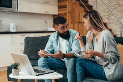 couple talks while looking at laptop