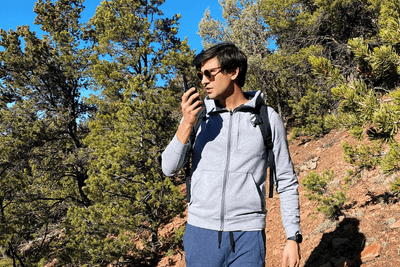 man hiking uses walkie talkie