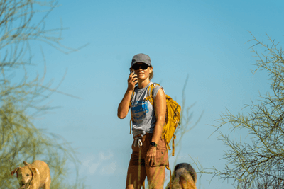 woman uses walkie talkie on hike