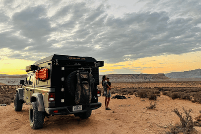 mother and child stand outside overlanding vehicle