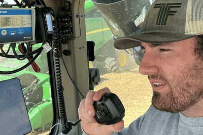 man uses MicroMobile mic in cab of tractor