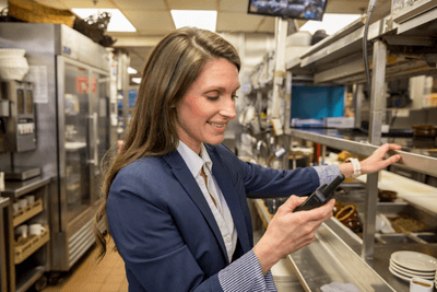 woman using business radio in kitchen at restaurant