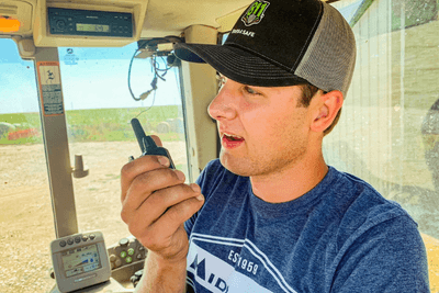 man in tractor cab with walkie talkie