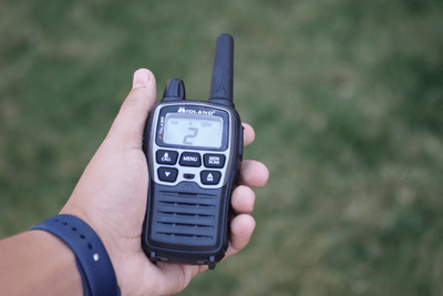 hand holds silver and black walkie talkie