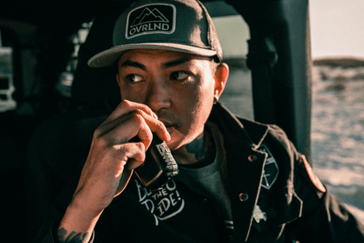 man holds Jeep walkie talkies in his vehicle