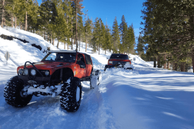 off-road vehicles go through snow in woods
