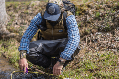 fly fishers looks at net in water