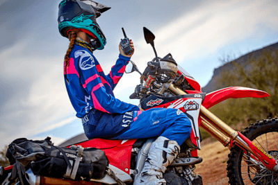 motorcyclists holds walkie talkie while sitting on bike