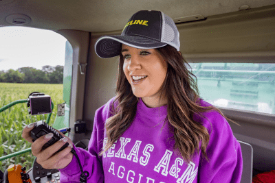 girl in tractor gab holds MicroMobile mic in hand