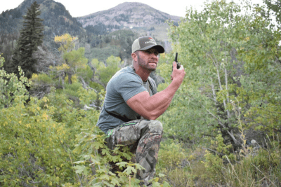 man uses walkie talkie in bushes